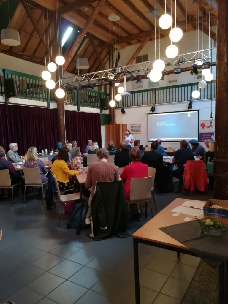 de zaal met mensen bij de start van het Stigma Café